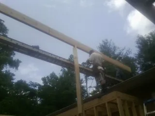 Carpenter setting a ridge beam over a new addition frame — Ice Dam Removal by Roofing Brothers in Berlin Heights