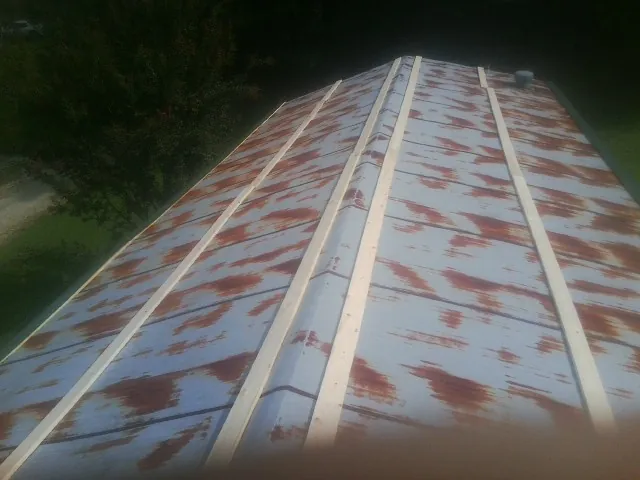 Rusted metal roof panels with new wood purlins before replacement — Storm Damage Roof Repair in Berlin Heights by Roofing Brothers