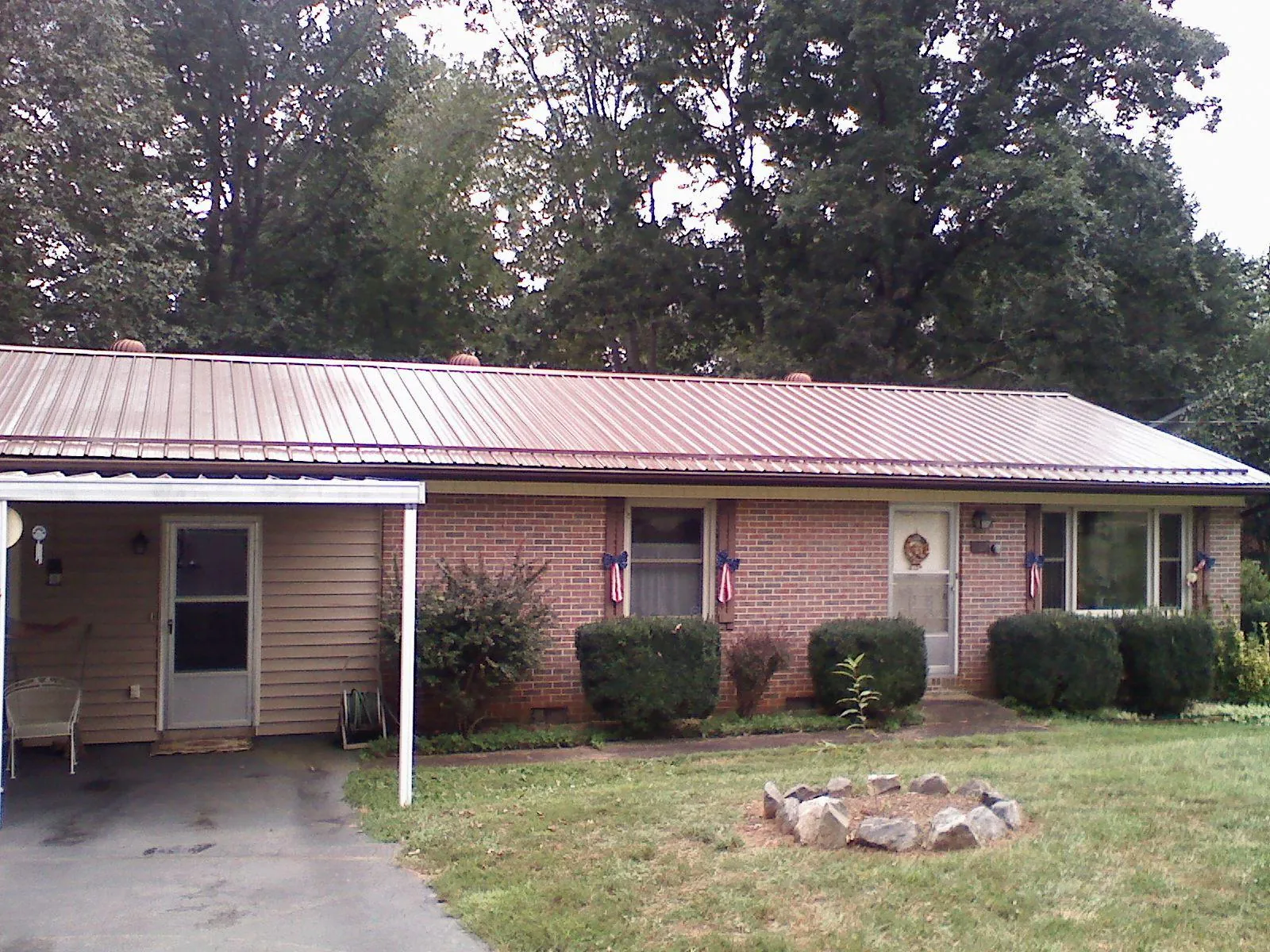 Bronze metal roof and carport on a brick ranch home — Roof Repair work by our crew in Berlin Heights