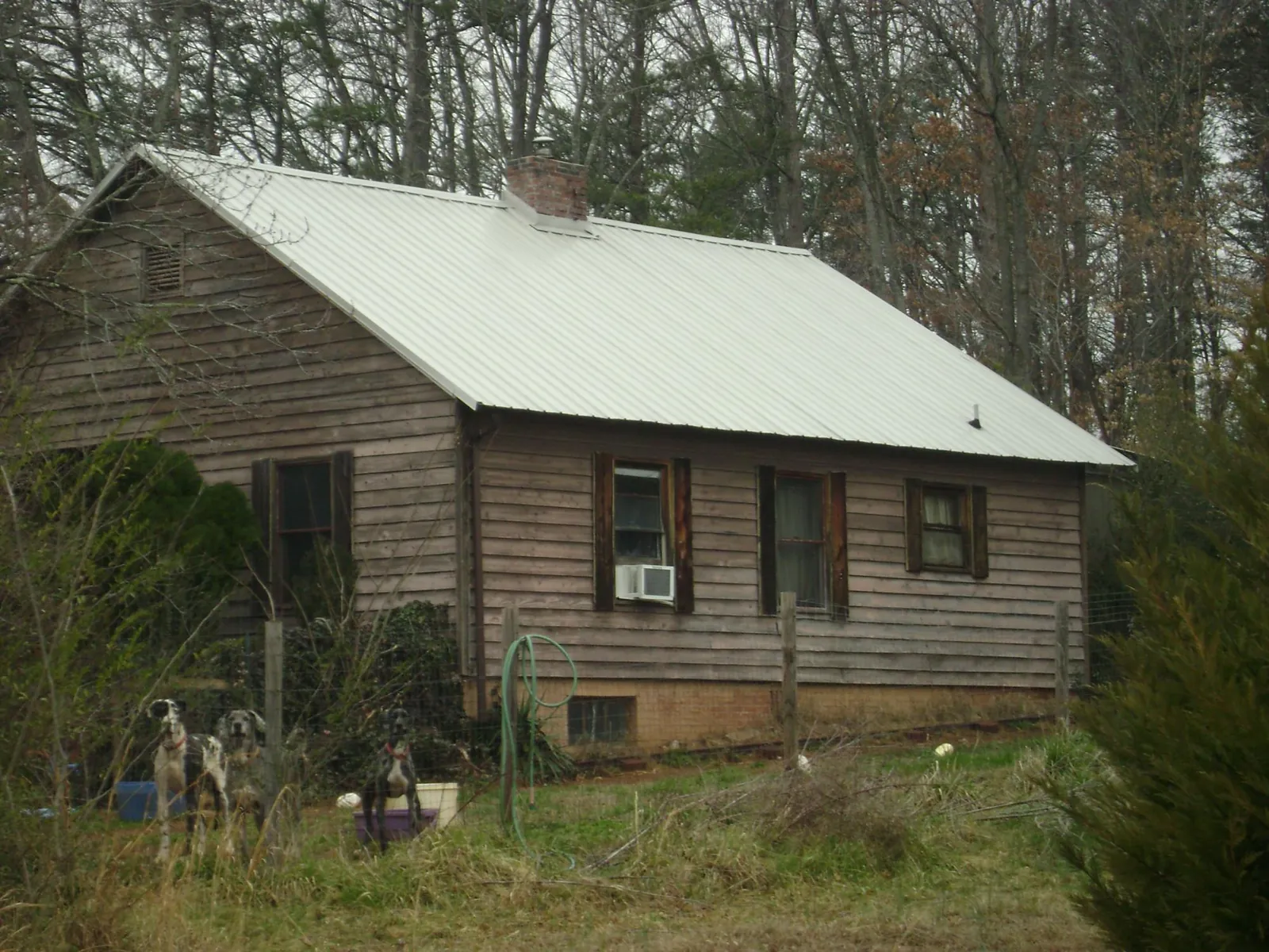 White metal roof on an old wood sided farmhouse, from a Metal Roof Installation job in Berlin Heights